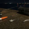 夜の堤防に並べた太刀魚釣りのウキ仕掛け、テンヤ、ワインド用ジグヘッド
